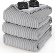 three gray blankets stacked on top of each other with two black speakers attached to them