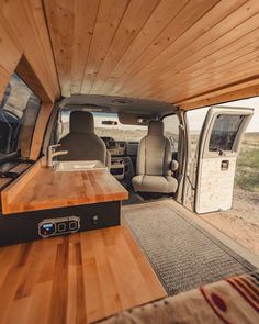 the interior of a van with wood paneling on the walls and wooden counter tops