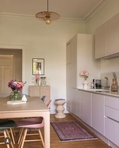 the kitchen is clean and ready to be used for dinner or lunch time, as well as flowers on the table