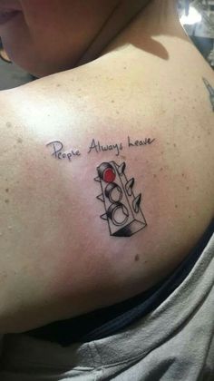 a woman with a tattoo on her shoulder that says hope always leaves, and an image of a traffic light