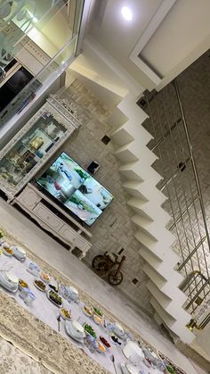 an overhead view of a dining room table with plates on it and a television in the background