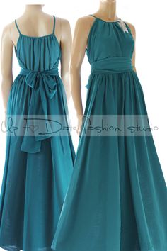 two mannequins dressed in teal colored dresses