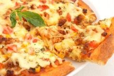 two slices of pizza on a white plate with basil and tomato toppings, ready to be eaten