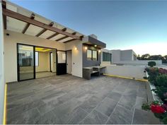 an outdoor patio with stone flooring and white walls