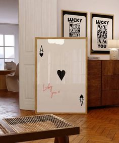 a couple of framed pictures sitting on top of a wooden floor next to a table