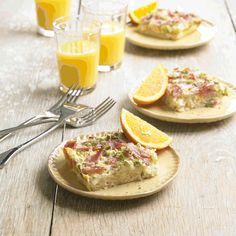 there are three plates with food on them next to oranges and silver utensils