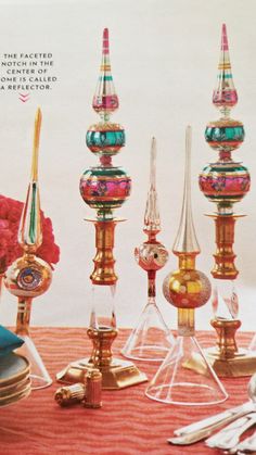 there are many different colored glass items on the table together, including candlesticks and spoons