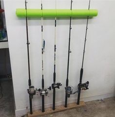 several fishing rods are lined up against the wall