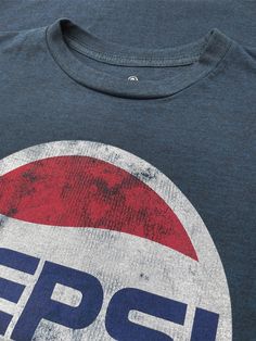 Vintage Never Looked So Good There's nothing like a classic Pepsi Cola! Inspired by the refreshing and absolutely timeless taste - our team created a retro 70s-inspired tee just for Pepsi fans. We selected the classic 70s Pepsi logo and gave it a fun, distressed and faded look. To complete the vintage feel on this Pepsi logo shirt - we've printed it on the highest quality, poly-cotton navy heather tee we could find. Poly/cotton blend Machine Wash Tumble Dry Regular Fit Printed in USA Retro Crew Neck Top With Graphic Print, Retro Graphic Print Crew Neck Top, Retro Tri-blend Graphic Print Tops, Retro Tri-blend Crew Neck T-shirt, Retro Cotton Tops With Logo Print, Retro Blue Soft-washed T-shirt, Retro Tri-blend T-shirt With Front Print, Retro Crew Neck Tops With Screen Print, Retro Soft-washed Crew Neck T-shirt