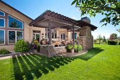 a house with a covered patio in the front yard and grass on the lawn below