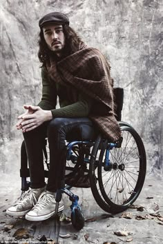 a man with long hair sitting in a wheelchair