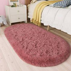 a pink rug on the floor in a bedroom