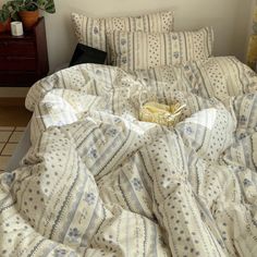 an unmade bed with white and blue sheets