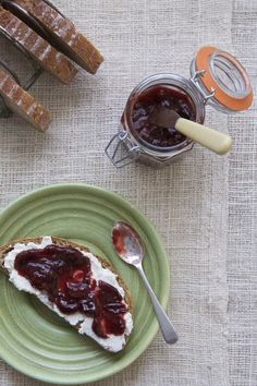 a piece of bread with jam on it sitting on top of a green plate