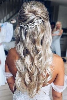 the back of a bride's head with her hair in half - up style