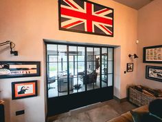 a living room filled with furniture and framed pictures on the wall next to a doorway