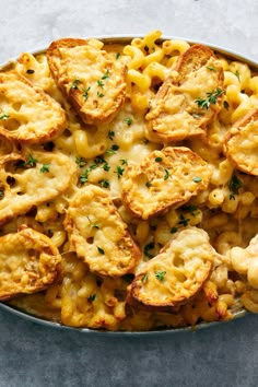 macaroni and cheese with parsley in a skillet on a gray surface