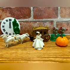 a wooden table topped with figurines next to a brick wall