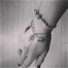 black and white photograph of a woman's hand with tattoos on her left wrist