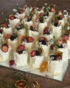 there are many different types of cakes on the table with flowers and fruit in them