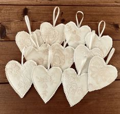 white heart shaped ornaments hanging from string on wooden background