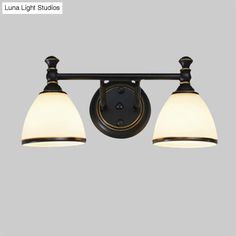 two light bathroom fixture with white glass shades on the top and black metal fixtures below