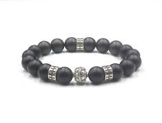 This bracelet features 10mm matte black onyx beads accented with four sterling silver Bali beads. We use silicon stretch cord for superior strength. Choose your wrist size from the drop down menu. We will make your bracelet to fit. Your bracelets comes in a bracelet gift box. Check out our Bracelets for Men: https://www.etsy.com/shop/KartiniStudio?section_id=16866423&ref=shopsection_leftnav_2 Check out our men's Deluxe Bracelets: https://www.etsy.com/shop/KartiniStudio?ref=hdr_shop_menu& Classic Black Bracelets With 8mm Beads, Classic Black Onyx Bracelets, Classic Black Onyx Bracelet, Elegant Black Beaded Bracelets With 8mm Beads, Black Wristband With 8mm Beads, Black Onyx Stretch Bracelet With 8mm Beads, Black Onyx 8mm Beads Stretch Bracelet, Mens Bracelet Black, Bracelet Gift Box