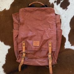 Awesome Camping/Beach/Traveling Backpack. This Bag Is Awesome Because It Can Either Be Buckled Or Unsnapped For Quick Access To Your Things. In A Lovely Rosey Wine Burgundy Color. It Fits A Lot Of Stuff And The Woven Straps Are Very Comfortable And Soft. Vintage Leather Standard Backpack, Everyday Leather-handled Coated Canvas Backpack, Vintage Standard Backpack For Everyday, Vintage Style Everyday Backpack, Everyday Coated Canvas Leather Backpack, Coated Canvas Standard Backpack For Travel, Everyday Standard Backpack With Waxed Finish, Brown Waxed Finish Backpack Satchel, Brown Coated Canvas Standard Backpack