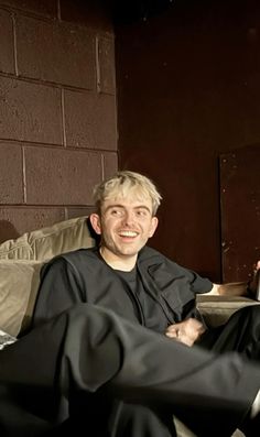 a man sitting on top of a couch next to another person