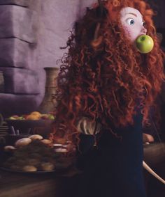 a woman with long red hair has an apple in her mouth