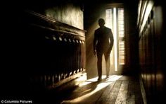 the silhouette of a man standing in an open doorway