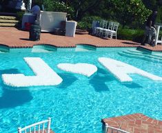 an outdoor pool is decorated with lawn chairs and large letters that spell out the word sale