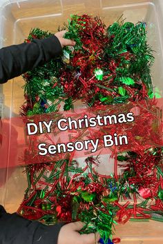 a plastic container filled with lots of christmas tinsely bins and small children's hands