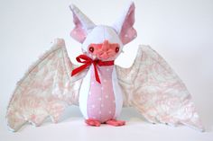 a stuffed animal bat with pink and white wings