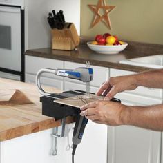 a man is using a scissor to cut up something on a cutting board