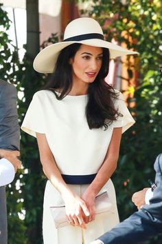 a woman wearing a white hat and dress