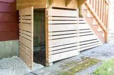 an outhouse with wooden slats on the side and stairs leading up to it