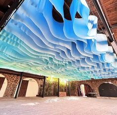 an artisticly designed ceiling in the lobby of a building with blue and white walls