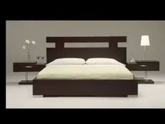 a bed sitting in the middle of a room with two lamps on either side of it