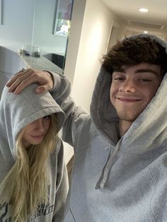 a young man and woman in grey hoodies