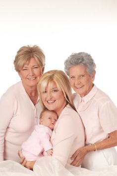 an older woman and two younger women holding a baby