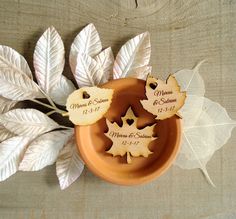 some leaves are sitting in a small bowl on a table with the names and date