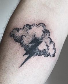 a man's arm with a lightning and cloud tattoo on the left side of his arm