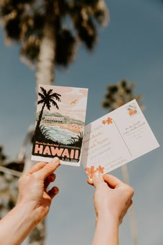 someone holding up a card with the word hawaii on it in front of palm trees