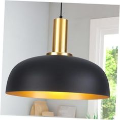 a black and gold colored pendant light hanging from a ceiling in a room with white walls