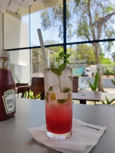 a drink sitting on top of a table next to a bottle of juice and paper towel