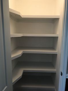 an empty white closet with shelves in it