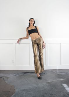 Vintage 90s bronze soft leather mid/high rise pants. Fully lined. Cool buckle detail on waist. condition: excellent label: no tags  era: 90's fabric: leather size: marked US 2 waist: 30" hips: 36" rise: 10"- 12.5" inseam: 34" length: 42" | model measures 32"-26"-36" | 5'9" | ♡ We only sell vintage items. Vintage items may come with minor flaws. We will do our best to clean|mend every garment as needed. ♡ We love vintage and support sustainability. All items are sold as is.  ♡ Returns are not acc Metallic Straight Leg Leather Pants For Night Out, Fitted Straight Leg Gold Pants, Gold Fitted Straight Leg Pants, Chic Metallic Straight Leg Leather Pants, Chic Fitted Metallic Leather Pants, Fitted Metallic Wide-leg Pants, Fitted Wide Leg Metallic Pants, Fitted Gold Wide Leg Pants, Kick Flare Pants