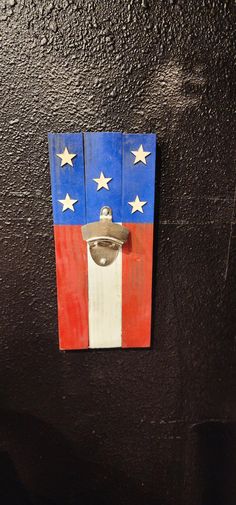 an american flag painted on the side of a black wall with a metal door handle