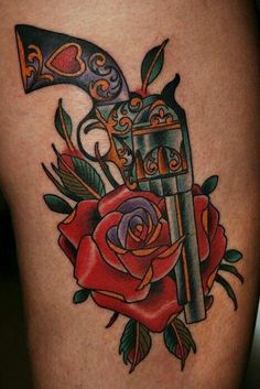 a rose and dagger tattoo on the thigh